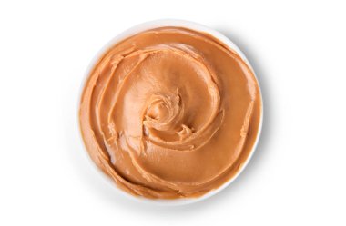 Beyaz arka planda izole edilmiş küçük bir kasede kremalı fıstık ezmesi. Üst görünüm.