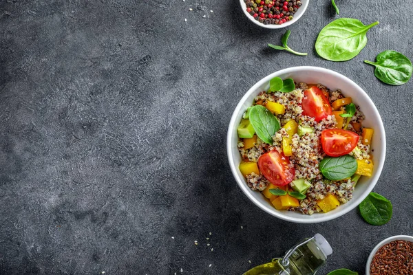 Siyah arka planda domatesli kinoa salatası, batata ve ıspanak. Vegan gıda konsepti. Üst Manzara. Boşluğu kopyala.