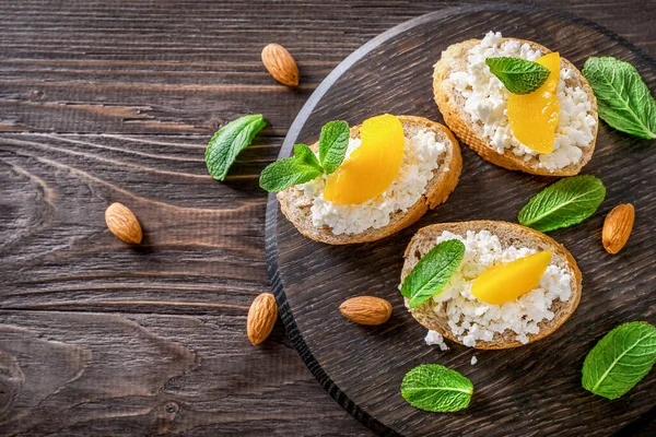 Süzme Peynirli Ekmek Dilimleri Nane Yaprakları Şeftali Parçaları Ahşap Arka — Stok fotoğraf