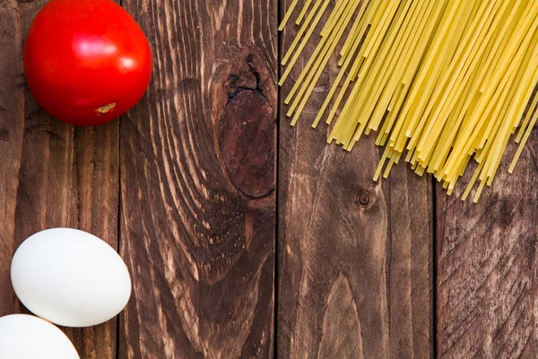 Spagetti, domates ve yumurta ahşap bir masa üzerinde