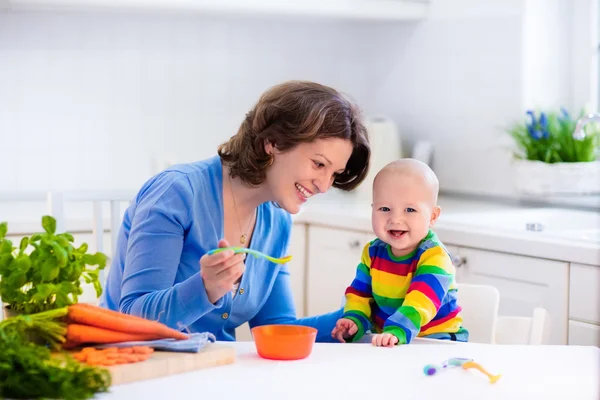 Mãe alimentando bebê primeiro alimento sólido — Fotografia de Stock