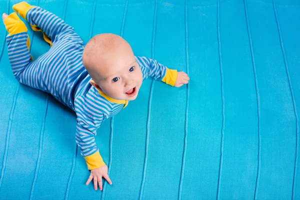 Мальчик на синем трикотажном одеяле — стоковое фото