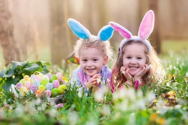 Çocuklar çiçeklenme içinde Paskalya yumurtası avına Bahçe bahar — Stok fotoğraf