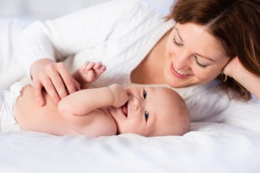 Anne ve bebek beyaz bir yatakta