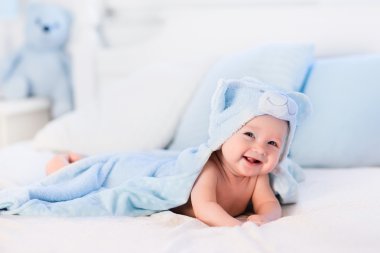 Mavi havlu beyaz yatakta erkek bebek