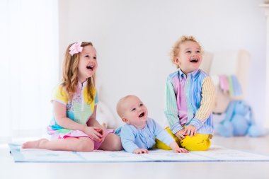 Beyaz yatak odasında oynayan çocuklar