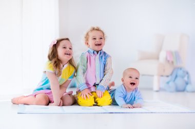 Beyaz yatak odasında oynayan çocuklar