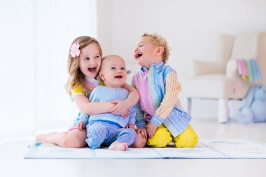Beyaz yatak odasında oynayan çocuklar