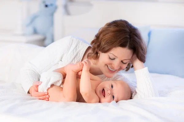 Anya és a baba egy fehér ágy — Stock Fotó