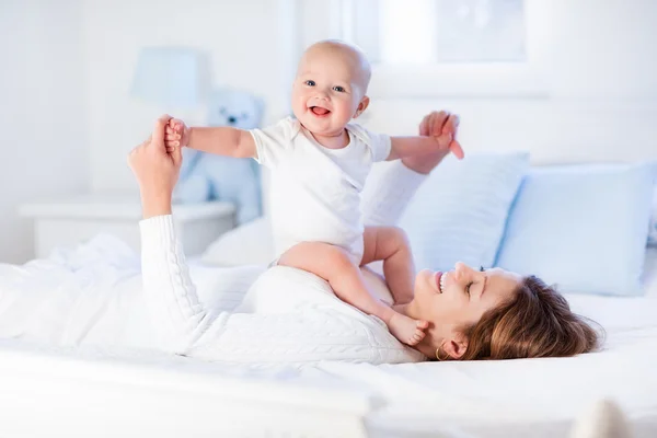 Madre e bambino su un letto bianco — Foto Stock