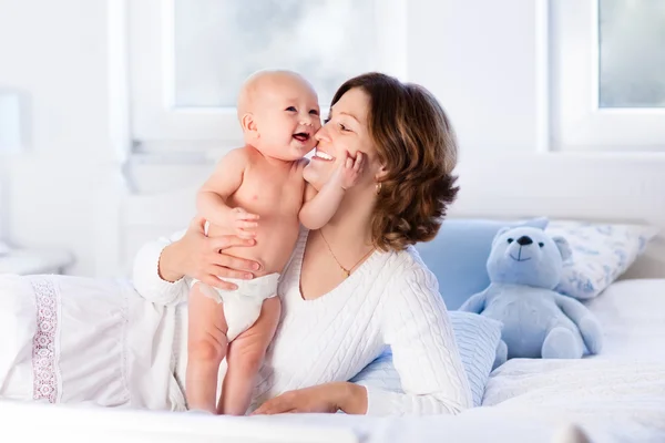 Madre y bebé en una cama blanca — Foto de Stock