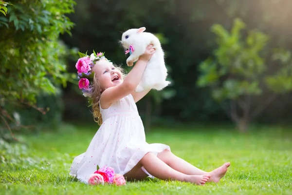 Little girl playing with real rabbit — Stock Photo, Image