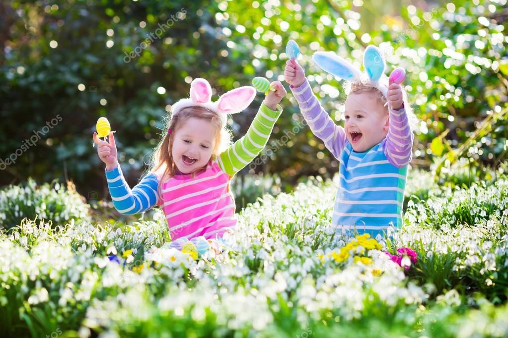 Kids on Easter egg hunt in blooming spring garden — Stock Photo