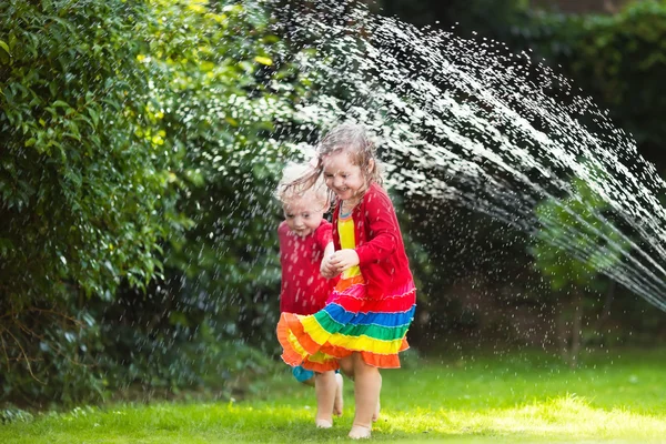 Crianças brincando com aspersor de jardim — Fotografia de Stock