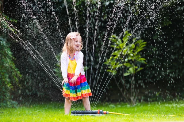 Kids playing with garden sprinkler — Stock Photo, Image