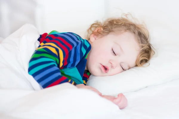 Linda niña durmiendo en una cama blanca — Foto de Stock