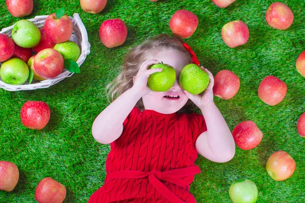 Little girl eating apples — Stock Photo, Image