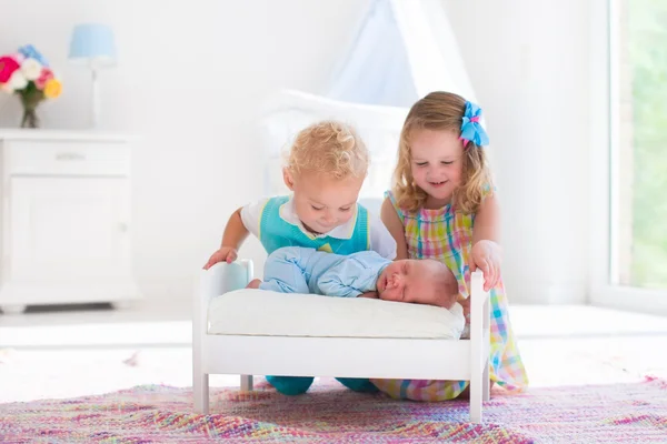 Pequeño niño y niña conocer nuevo hermano — Foto de Stock