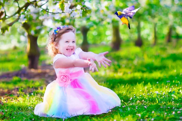 Little girl in fairy costume feeding a bird — Stock Photo, Image