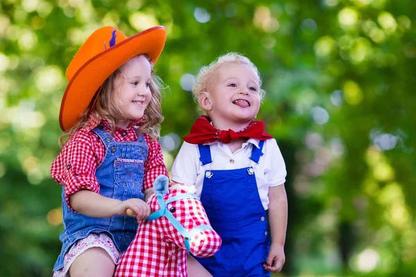 Cowboy crianças brincando com brinquedo cavalo — Fotografia de Stock