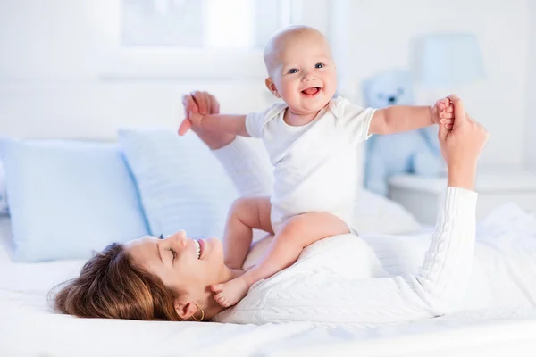 Mãe e bebê em uma cama branca — Fotografia de Stock