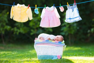 Baby boy on a pile of towels outdoors clipart