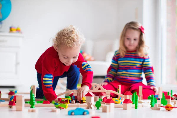 Children playing with toy railroad and train