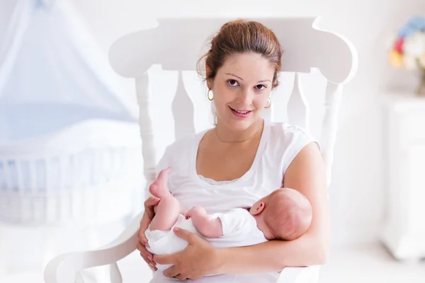 Mãe e bebê recém-nascido em berçário branco — Fotografia de Stock