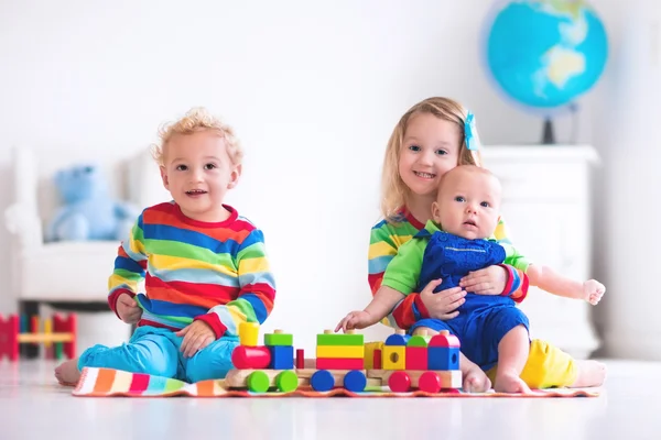 Kids playing with wooden toy train — Stock Photo, Image