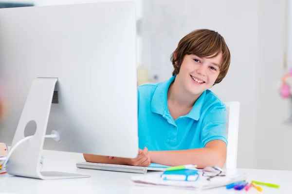 Menino fazendo lição de casa com computador moderno — Fotografia de Stock