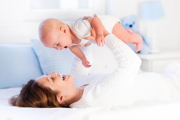 Mãe e bebê em uma cama branca — Fotografia de Stock