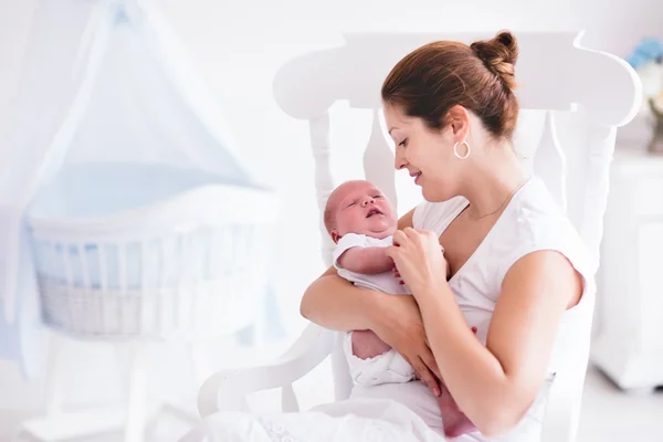 Mãe e bebê recém-nascido em berçário branco — Fotografia de Stock