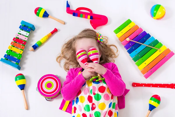 Маленькая девочка с музыкальными инструментами — стоковое фото