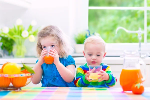 Barn som drikker appelsinjuice – stockfoto