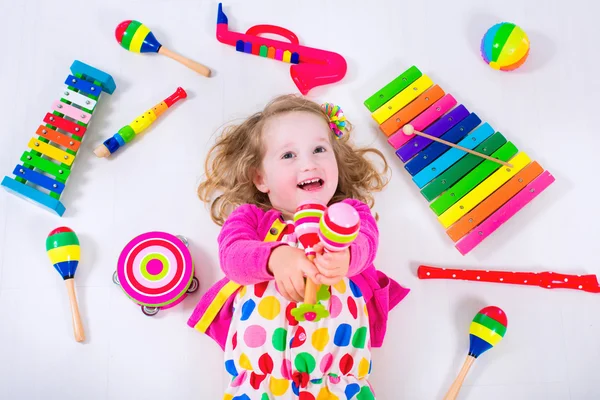 Kleines Mädchen mit Musikinstrumenten — Stockfoto