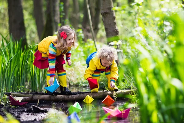 Bambini che giocano con barche di carta colorate in un parco — Foto Stock