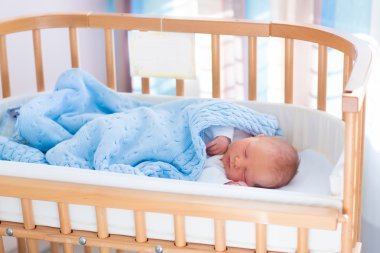 Newborn baby boy in hospital cot