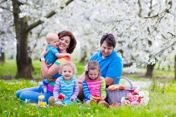 Gezin met kinderen genieten van picknick in het park van de lente — Stockfoto