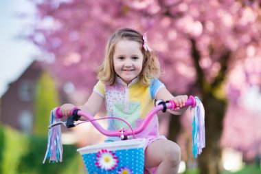 Little girl riding a bike on sunny spring day