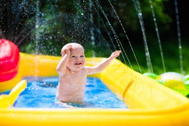 Happy baby playing in swimming pool clipart