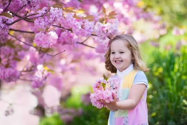 Liten flicka med körsbärsblommor — Stockfoto