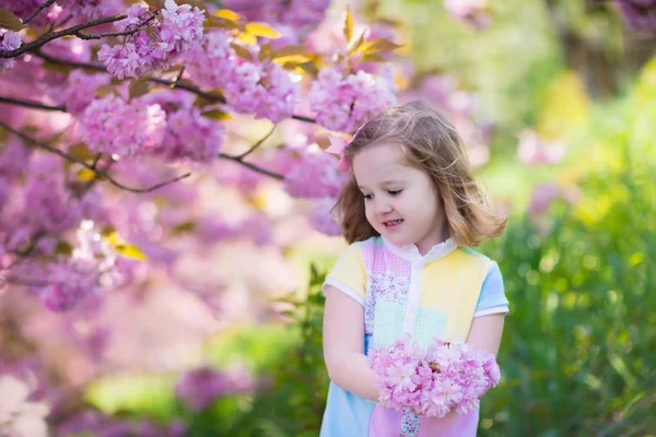 Little girl with cherry blossom — Stock Photo, Image