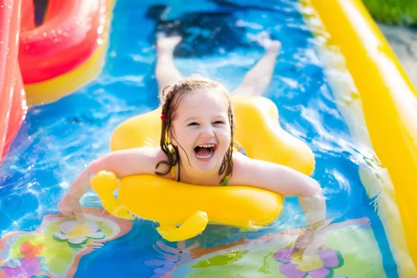 Mała dziewczynka gra w nadmuchiwany basen ogrodowy — Zdjęcie stockowe