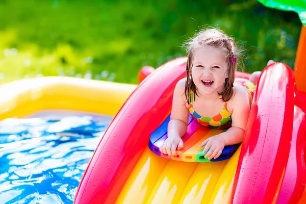 Liten flicka som leker i Uppblåsbara trädgård pool — Stockfoto