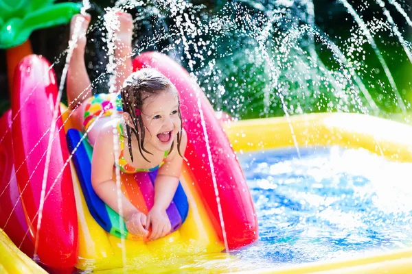 Menina que joga na piscina inflável do jardim — Fotografia de Stock