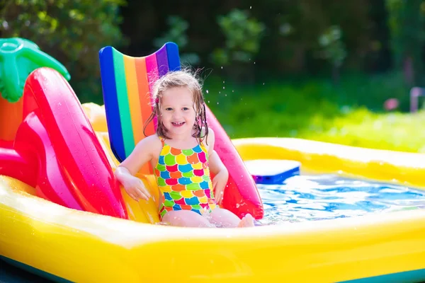 Meisje spelen in opblaasbare tuin zwembad — Stockfoto