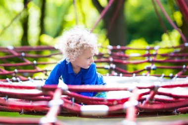 Okul bahçesinde oyun parkında eğlenceli olan çocuğun