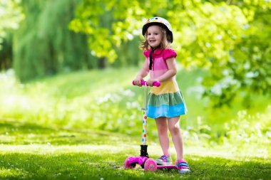Küçük kız renkli bir scooter sürme