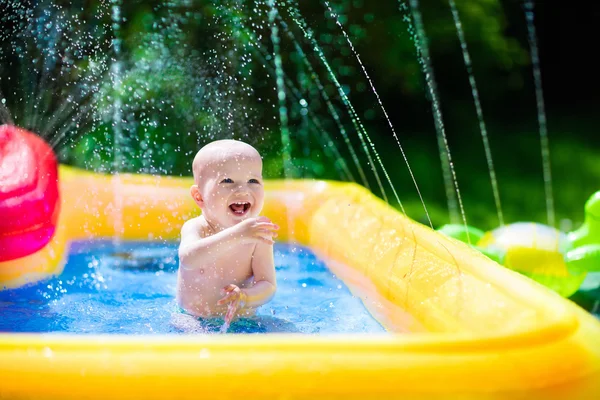 Happy baby playing in swimming pool — Stock Photo, Image