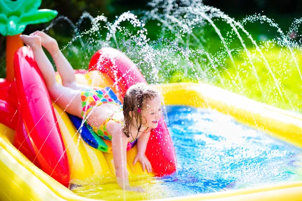 Liten flicka som leker i Uppblåsbara trädgård pool — Stockfoto